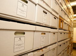 View of university records in archival boxes in the archives storage facility in Aquinas Hall
